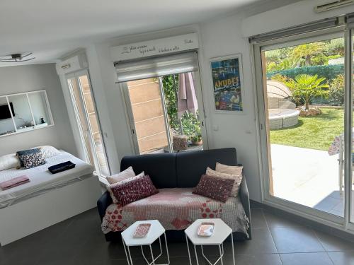 un salon avec un canapé et un lit dans l'établissement Joli studio climatisé avec Jardin dans résidence avec piscine, à Antibes