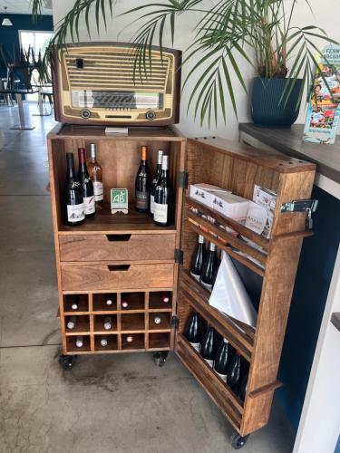 a drink cart with wine bottles and an old radio at Hotel Caiman in Pierrelatte