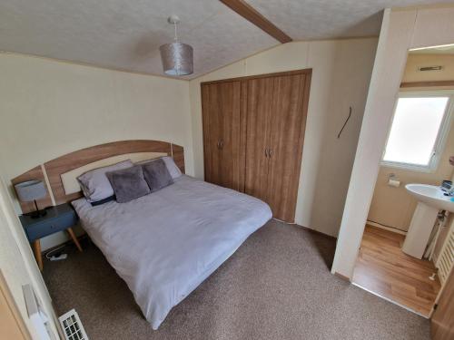 a small bedroom with a bed and a sink at B17 Sunnymede Caravan Park, Fantasy Island, Ingoldmells in Ingoldmells