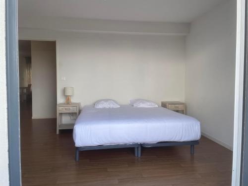 a bedroom with a bed with a white bedspread at Zenao Appart'Hotel in Nevers
