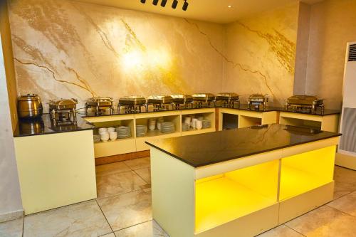 a kitchen with a yellow counter in a room at Vintano Hotel in Lekki