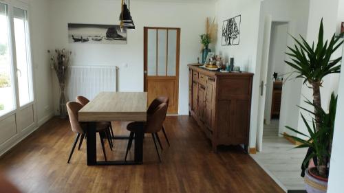 une salle à manger avec une table et des chaises en bois dans l'établissement Du jouet, à La Roche-Derrien