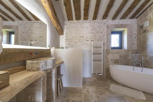 une salle de bain avec une baignoire et un lavabo dans l'établissement Le Mas des Oliviers, à Châteaurenard