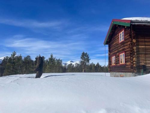 a log cabin with snow in front of it at Rondane Sollia Friluftsliv Øvre Nordli in Sollia
