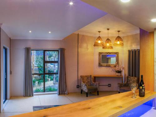 a living room with a table and a window at Bishops Lodge in Gqeberha