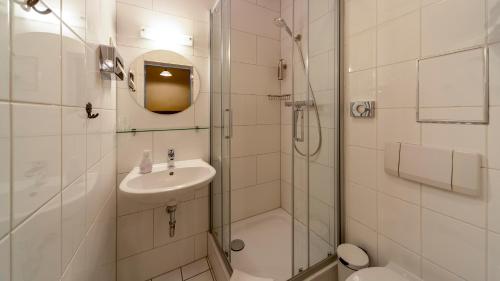a bathroom with a shower and a sink and a toilet at Gästehaus Mezcalero in Dresden