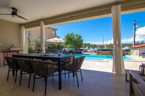 a dining room with a table and chairs and a pool at Villa Marin in Klimno