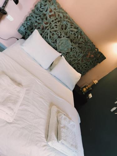 a bedroom with a bed with white sheets and pillows at MARRAKECH פלא - PELEH - Queit place 3 km from the beach of Cesarea in Or ‘Aqīvāh