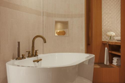 a white bath tub with a sink in a bathroom at Jumeirah Beach Hotel Dubai in Dubai