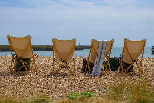 three lawn chairs sitting on the beach at Modern Seaside Townhouse feat Sauna near Brighton in Shoreham-by-Sea