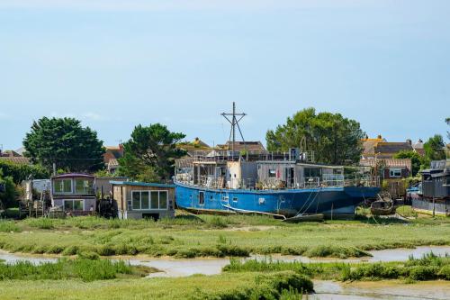a blue boat sitting in a field next to houses at Modern Seaside Townhouse feat Sauna near Brighton in Shoreham-by-Sea