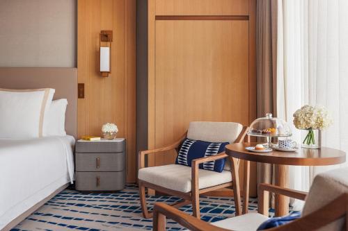 a hotel room with a bed and a table and chair at Jumeirah Beach Hotel Dubai in Dubai