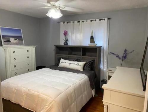 a bedroom with a bed and a ceiling fan at North Hill Cottage in Pensacola