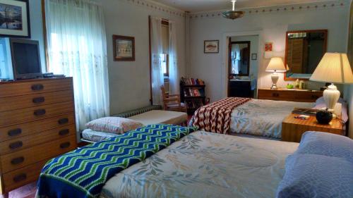 a bedroom with two beds and a dresser at Fish & Loaves Bed and Breakfast in Numidia