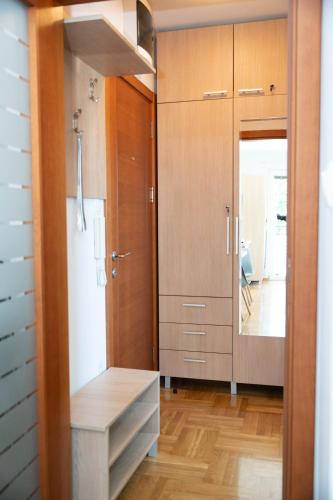 a bathroom with wooden cabinets and a large mirror at Flowers Oasis Studio Vrnjačka Banja in Vrnjačka Banja
