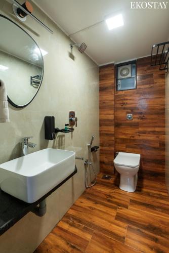 a bathroom with a white sink and a toilet at EKOSTAY Gold - White Swan Villa 6BHK in Panchgani
