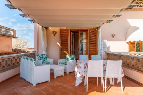 a balcony with white chairs and tables on a balcony at Hotel Sonia in Forte dei Marmi