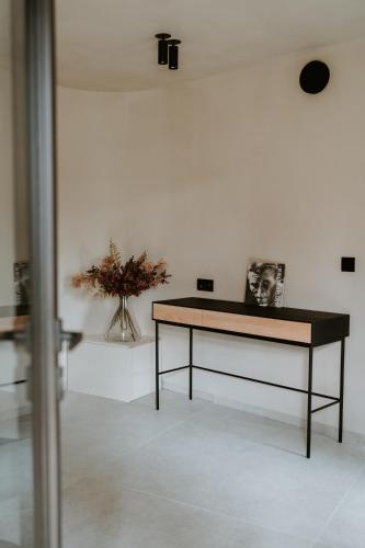 a table in a room with a vase of flowers at Gerard Bronnen in Geraardsbergen