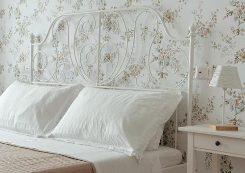 a white bed with a white headboard and a table at Feudi di Bisaccia in Montenero di Bisaccia