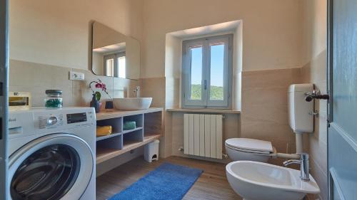 Un baño con lavadora y lavabo. en Casanova di Bricciano, en Gaiole in Chianti