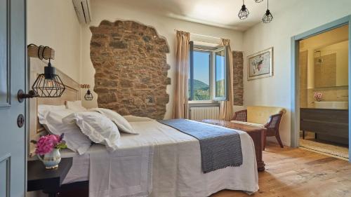 Un dormitorio con una cama y una pared de piedra. en Casanova di Bricciano, en Gaiole in Chianti