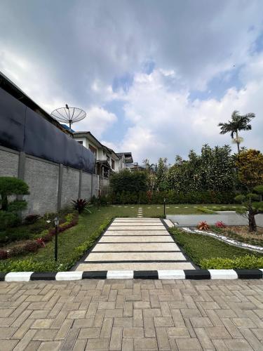 a stone walkway in front of a building at VILLA NEOM PUNCAk in Sampal 2
