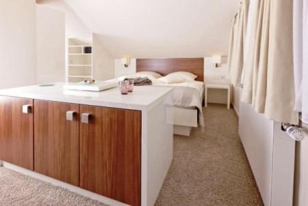 a bedroom with a bed and a bathroom with a sink at Restaurant Niedmühle Land & Genuss Hotel in Rehlingen-Siersburg