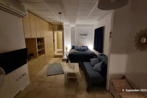 a living room with a couch and a bed in a room at Poseidons Retreat optional el car and airporttrans in Sounio