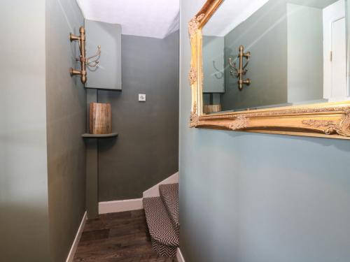 a mirror on a wall next to a stairway at West Pier Cottage in Macduff