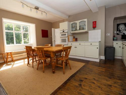 a dining room with a wooden table and chairs at New Hall in Wrexham