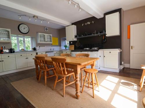 a kitchen with a wooden table and chairs at New Hall in Wrexham