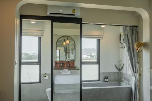 a bathroom with a shower and a tub and a sink at Ang Pao Hotel Phuket in Phuket Town