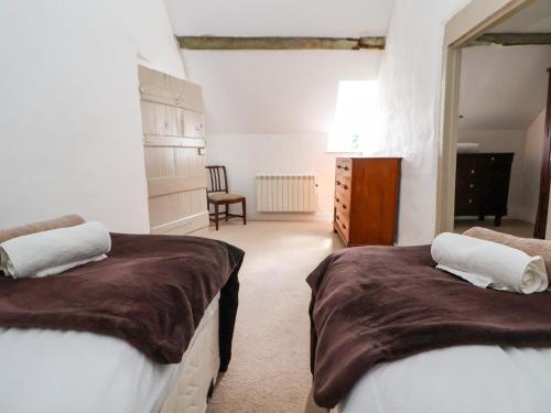 a bedroom with two beds and a dresser at New Hall in Wrexham