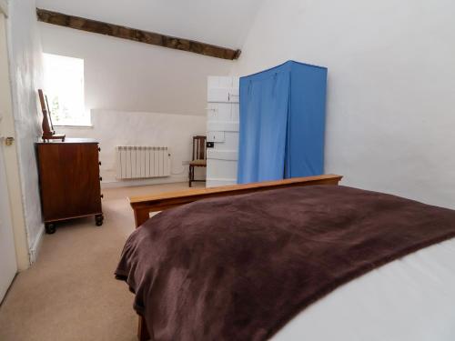 a bedroom with a bed and a blue cabinet at New Hall in Wrexham