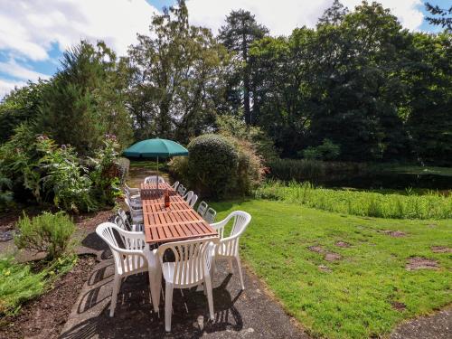 a table and chairs with an umbrella in a garden at New Hall in Wrexham