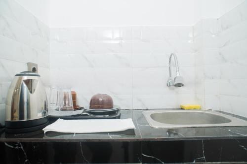 a kitchen counter with a sink and a mixer at Fun Living Guest House in Seminyak