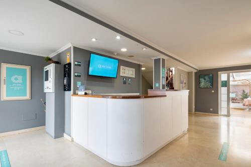 a large lobby with a counter with a tv on the wall at Hotel Alda Santa Cristina in Perillo