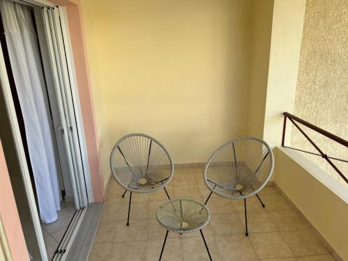 two chairs and a table in a room at Mesogaia Home Near ATH Airport in Markopoulo