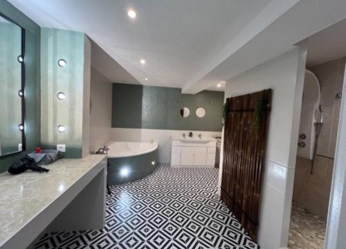 La grande salle de bains est pourvue d'une baignoire, d'un lavabo et d'une baignoire. dans l'établissement Grande longère à la campagne, à Précy-sur-Vrin