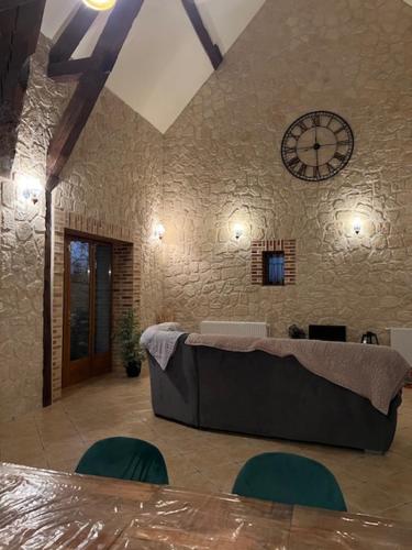 une pièce avec une table et une horloge au mur dans l'établissement Grande longère à la campagne, à Précy-sur-Vrin