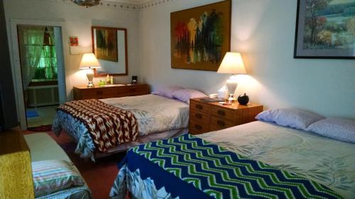 a hotel room with two beds and two lamps at Fish & Loaves Bed and Breakfast in Numidia