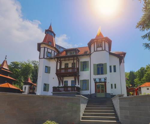 a large white house with turrets on top of a wall at Turul Villa in Sovata