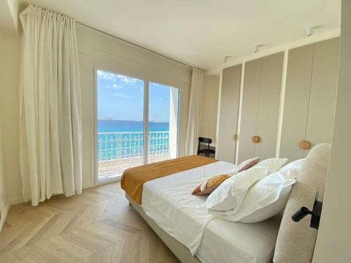 une chambre avec un grand lit avec une grande fenêtre dans l'établissement Villa des Prophètes - Corniche Marseille- Bord de Mer- Vue Unique- Plage, à Marseille