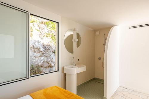 une salle de bain avec un lavabo et un miroir dans l'établissement Villa des Prophètes - Corniche Marseille- Bord de Mer- Vue Unique- Plage, à Marseille