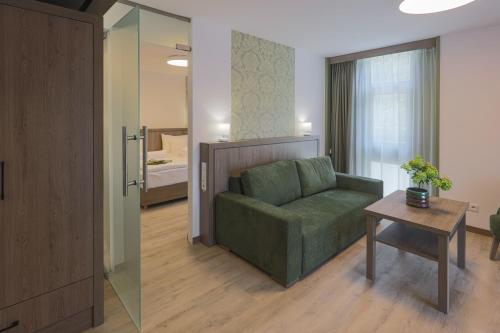 a living room with a green couch and a table at Turul Villa in Sovata