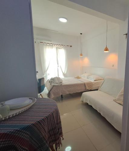 a white room with two beds and a couch at Afytos Dream suites sea view in Afitos