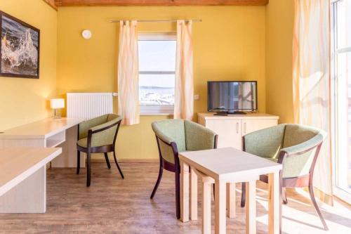 a living room with chairs and a table and a tv at Ferienwohnung mit Seeblick - Fischerhafen Plauer See in Plau am See
