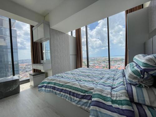 a bedroom with a bed and large windows at Apartement 2 Bedroom And 1 Living Room A22701 Pollux Habibi Batam Centre in Batam Center
