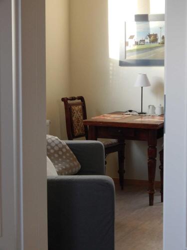 a living room with a table and a chair and a couch at Schnuckelige Ferienwohnung mitten in der Seenplatte in Blankensee