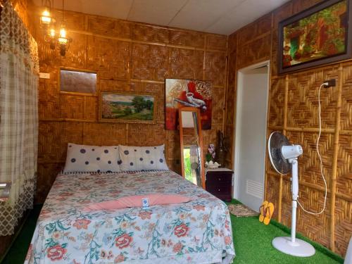 a bedroom with a bed and a fan in it at Hidden Tourist Inn in Abu